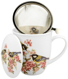 Kubek porcelanowy z sikorkami, zaparzaczem i odstawioną obok pokrywką, widok z góry.