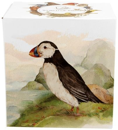 Ilustracja maskonura na boku pudełka – biało-czarny ptak z kolorowym dziobem na tle gór i morza.