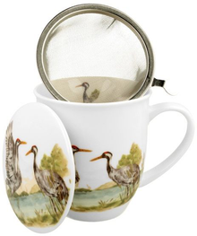 Kubek porcelanowy z zaparzaczem i pokrywką, ozdobiony wzorem żurawi zwyczajnych.
