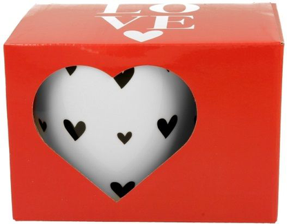 Ozdobne pudełko prezentowe z okienkiem w kształcie serca, przez które widać kubek porcelanowy z czarnymi serduszkami.