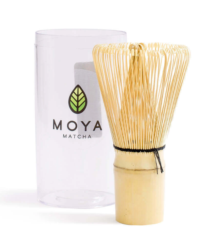 Bambusowy pędzelek do matchy chasen obok przezroczystego opakowania z logo Moya Matcha.