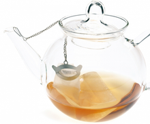 Szklany dzbanek z herbatą, w środku filtr papierowy zamknięty klipsem Finum na łańcuszku.