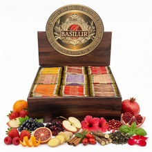 Elegancki zestaw herbat Basilur w pudełku, różne smaki w saszetkach, otoczony świeżymi owocami i przyprawami