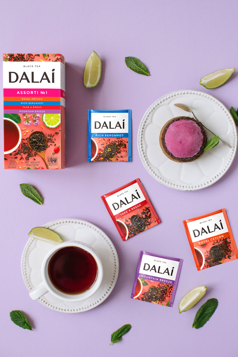 Dalai Assorti No 1 z pudełkiem, kopertami i filiżankami herbaty na fioletowym tle.