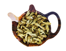 Suszona biała herbata Ya Bao Wild Tea Buds z delikatnych pąków dzikich krzewów, ułożona w drewnianym czajniczku.