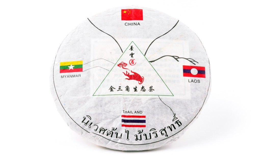 Sprasowana herbata Pu Erh Tea Cake Golden Triangle 357 g w formie tradycyjnego placka z oznaczeniami regionu Złotego Trójkąta.