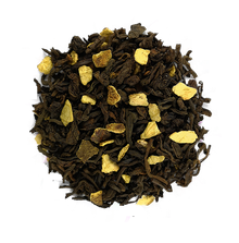 Susz herbaty czerwonej Pu Erh Pomarańczowa z dodatkiem skórki pomarańczy na drewnianej podstawce.