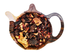 Susz owocowej herbaty Malinowy Fifrak z jabłkiem, hibiskusem, rodzynkami, truskawkami i malinami na drewnianej podstawce.