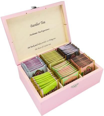 Drewniane pudełko Basilur w różowym kolorze z zestawem herbat w saszetkach.
