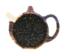 Suszona czarna herbata Rwanda Rukeri Organic w drewnianym czajniczku, widoczne ciemne, skręcone liście herbaty.