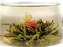 Rozkwitnięta herbata Flower Pearl z widocznym kwiatem w środku filiżanki.