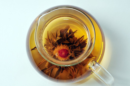 Widok z góry na dzbanek z zaparzoną herbatą rozkwitającą Flower Pearl w kształcie kwiatu.