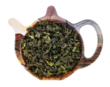 Liście chińskiej herbaty półfermentowanej Oolong K104 w czarce w kształcie czajniczka.