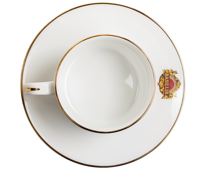 Widok z góry na filiżankę porcelanową Basilur ze spodkiem i złotym rantem.
