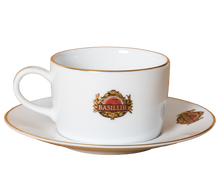 Filiżanka Basilur 265 ml ze spodkiem, porcelana z logo i złotym wykończeniem.