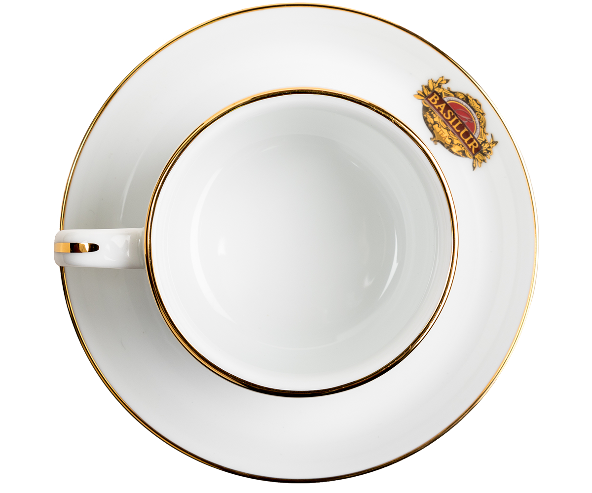 Widok z góry na filiżankę porcelanową Basilur ze spodkiem i złotym rantem.