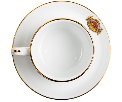 Widok z góry na filiżankę porcelanową Basilur ze spodkiem i złotym rantem.