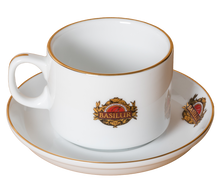 Filiżanka Basilur ze spodkiem, widok z boku, porcelana zdobiona złotym rantem.