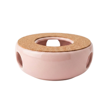 Ceramiczny podgrzewacz do herbaty w kolorze różowym z bocznymi otworami i korkową górą, widok z boku