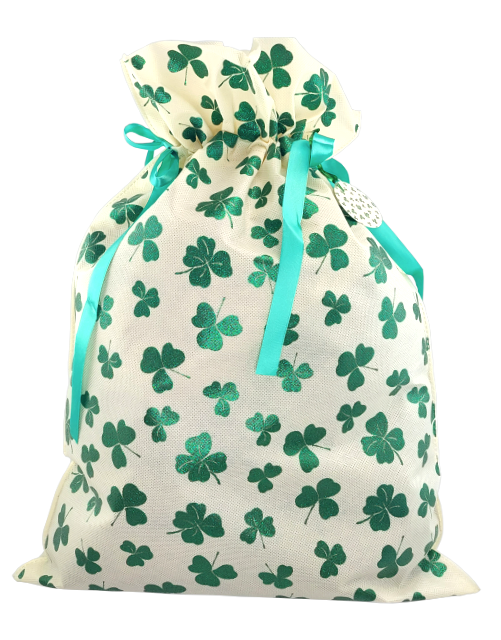 Jasny worek prezentowy w zielone koniczynki, przewiązany zieloną wstążką.