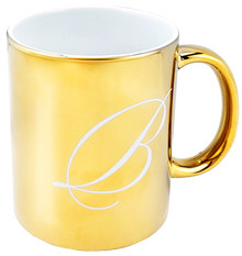 Elegancki kubek Basilur o złotym połysku z subtelnym grawerem, idealny do herbaty.