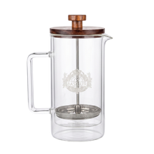 Szklany zaparzacz do herbaty Basilur Tea Press z metalowym filtrem i logo marki.