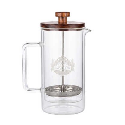 Szklany zaparzacz do herbaty Basilur Tea Press z metalowym filtrem i logo marki.