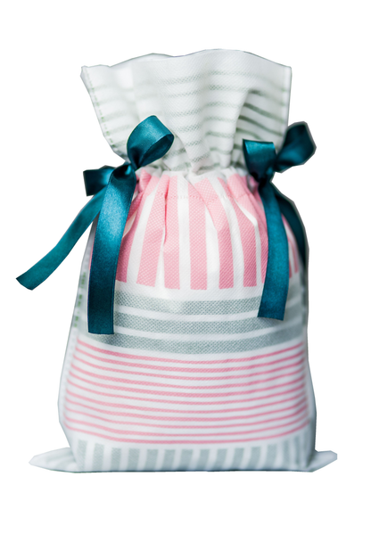 Pastelowy worek prezentowy 20 x 30 cm w różowo-szare paski, przewiązany granatową satynową wstążką.