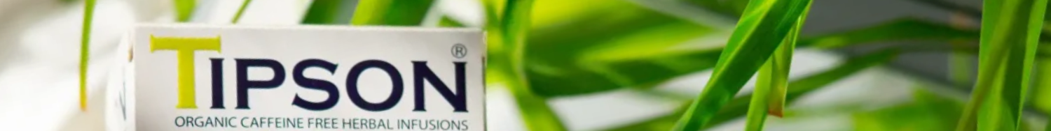 Opakowanie herbaty Tipson z widocznym logo marki, ustawione na tle zielonych liści, podkreślających naturalny i organiczny charakter produktu.
