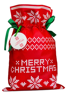Czerwony worek prezentowy z białym wzorem w gwiazdy betlejemskie, napisem Merry Christmas i zieloną wstążką.