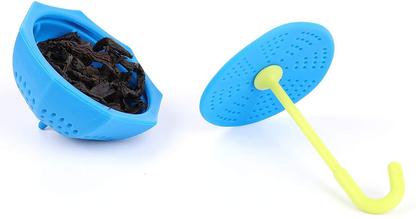 Otwarty zaparzacz parasolka z suszonymi liśćmi herbaty.