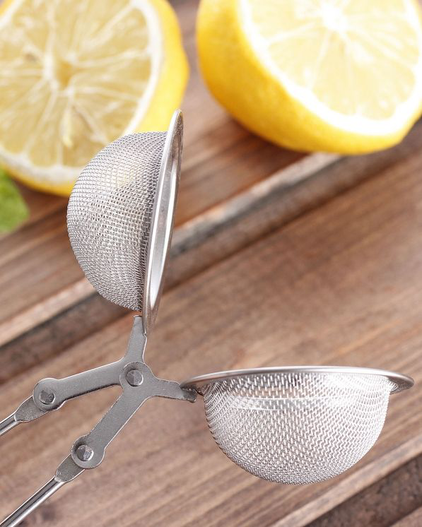 Otwarty zaparzacz do herbaty w kształcie szczypiec z widoczną siateczką