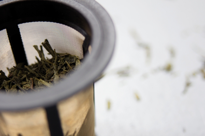 Zbliżenie na zaparzacz Finum z herbatą liściastą w środku
