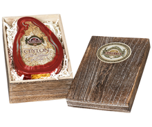 Otwarta skrzynka Basilur Crimson Paulownia z puszką w kształcie wyspy Sri Lanka.