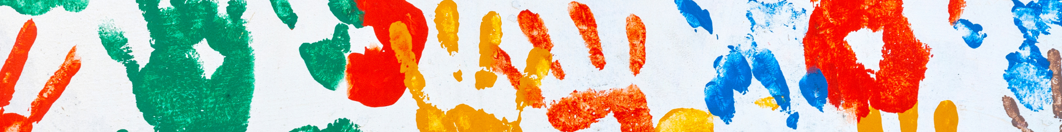 Kolorowe odciski dłoni w różnych barwach – czerwonych, zielonych, niebieskich i żółtych – na białym tle, tworzące dziecięcy, radosny wzór.