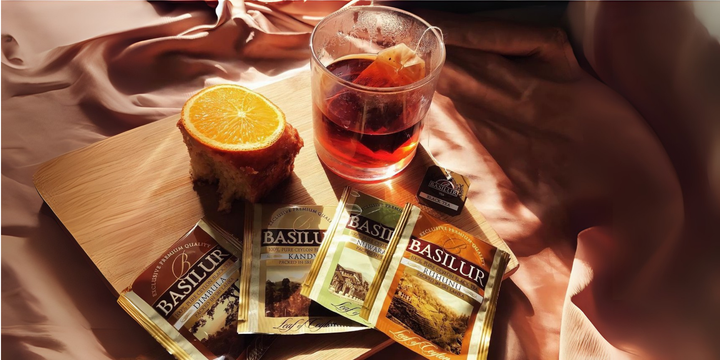 Herbata Basilur w torebkach – filiżanka czarnej herbaty z ciastem i pomarańczą