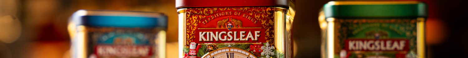 Metalowe puszki herbaty Kingsleaf w ozdobnych opakowaniach, z widocznym logo na czerwonym tle.