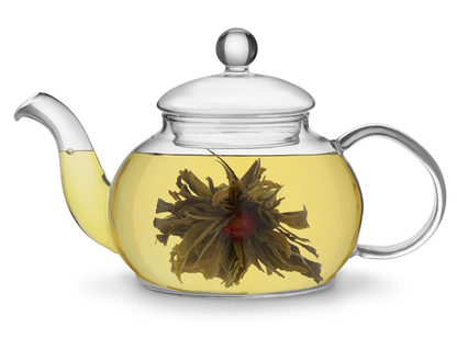 Zaparzona herbata rozkwitająca Rich Flower w szklanym dzbanku z widocznym kwiatem w środku.