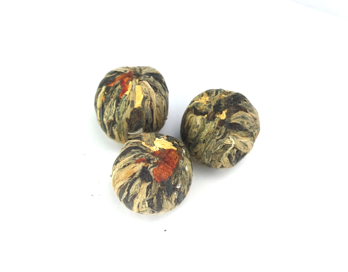 Trzy kulki herbaty rozkwitającej Liliowy Czar na białym tle
