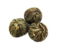 Trzy kulki herbaty rozkwitającej Podniebny Taniec Feniksa na białym tle
