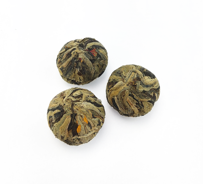 Zdjęcie trzech suchych kulek herbaty rozkwitającej Three Flower Beauty na białym tle