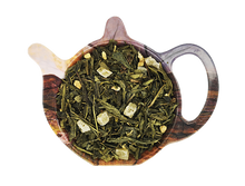 Zielona herbata Sencha Ananas i Imbir z kawałkami ananasa kandyzowanego i imbirem na podstawce w kształcie czajniczka