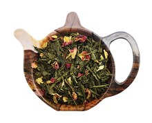 Zielona herbata Sencha Sekret Esmeraldy z płatkami róży i kwiatami słonecznika na podstawce w kształcie czajniczka