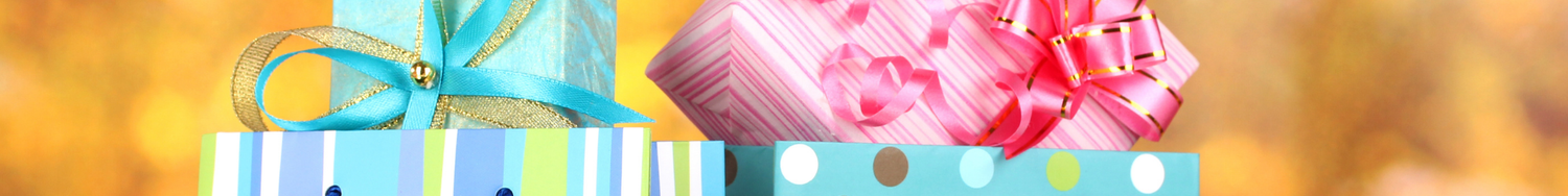 Kolorowe torby prezentowe z pudełkami owiniętymi wstążkami, w pastelowych odcieniach różu, błękitu i zieleni, na jasnym tle.